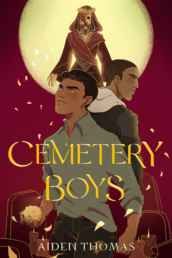 Book cover of Cemetery Boys by Aiden Thomas. Two boys stand back to back amidst tombstones and marigold petals. A half-skeletal lady hovers overhead.